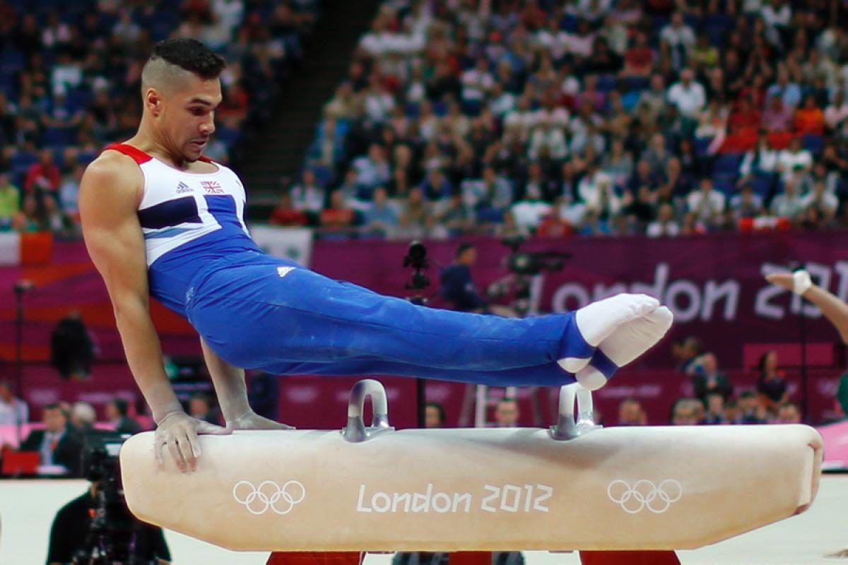 A male gymnast performs a flared element on the pommel horse at the London 2012 Olympics.
